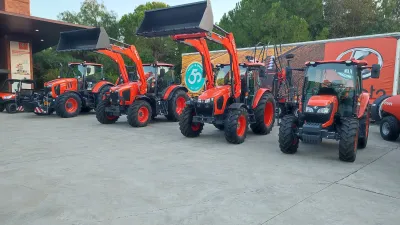 Traktory Kubota vystavené před budovou při oslavě výročí.
