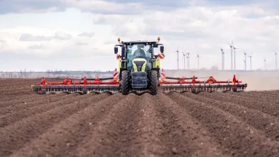Traktor s prutovými branami Pöttinger na poli