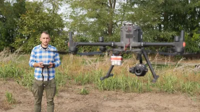 Muž ovládá dron nad polem