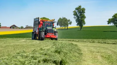 Sběrací vůz Pöttinger se zelenou hmotou na louce