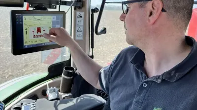 Řidič ovládá dotykový terminál v kabině traktoru