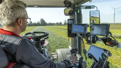 Řidič v kabině traktoru Massey Ferguson při práci na poli