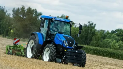 Modrý traktor New Holland na poli