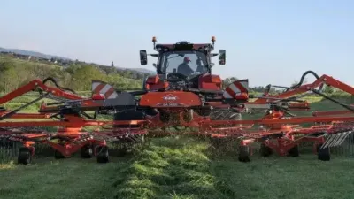 Červený zemědělský stroj KUHN při práci na poli
