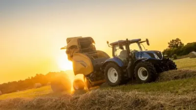 Lis New Holland na poli při západu slunce