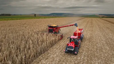 Kombajn Case IH plní přívěs při sklizni kukuřice