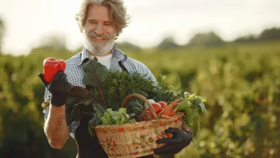 Farmář drží červenou papriku a košík zeleniny