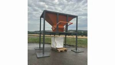 Oranžová plnicí násypka na kovovém rámu