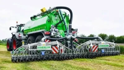 Traktor táhne zelenou cisternu Joskin s aplikátorem