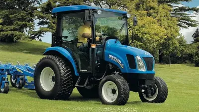Modrý traktor New Holland Boomer na trávníku