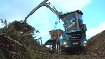 Štěpkovač Jenz Cobra zvedá větve hydraulickou rukou.