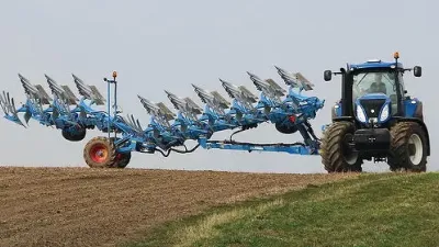 Modrý traktor s otočným pluhem Lemken na poli