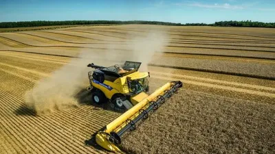 Žlutá sklízecí mlátička New Holland při sklizni obilí