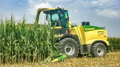Zelenožlutá samojízdná řezačka Krone při sklizni kukuřice