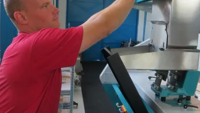 Pracovník nastavuje barevný třídič ve výrobní hale