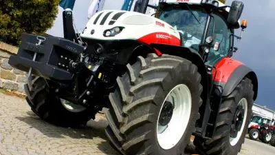 Červeno-bílý traktor Steyr u výstavních vlajek