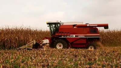 Červená sklízecí mlátička Laverda MX při sklizni kukuřice