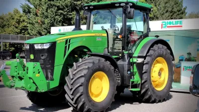 Zelený traktor John Deere vystavený na veletrhu