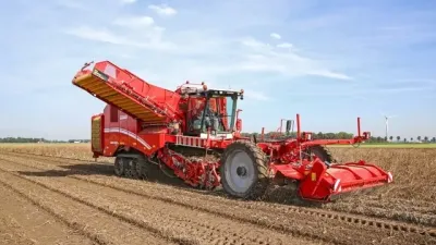 Červený samojízdný sklízeč brambor Grimme Varitron 470 na poli.