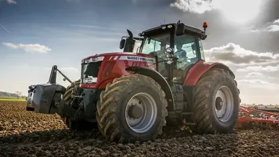 Červený traktor Massey Ferguson při práci na poli
