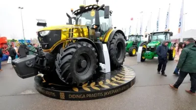 Pozlacený traktor John Deere vystavený na veletrhu