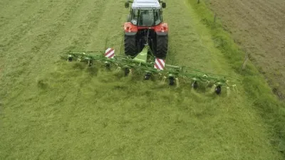 Traktor s obracečem píce Krone na louce