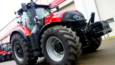 Červený traktor Case IH Optum před halou
