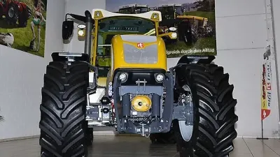 Čelní pohled na žlutý traktor Rigitrac ve výstavní hale