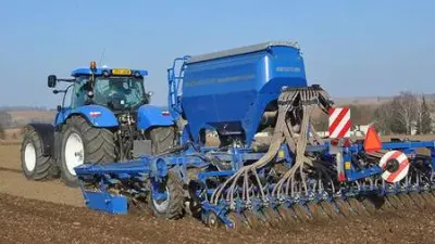 Modrý traktor se secím strojem Köckerling Vitu 600 na poli