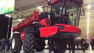 Červený samojízdný postřikovač Agrifac Condor Endurance vystavený v hale.