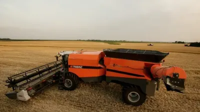 Oranžový kloubový kombajn Tribine na poli