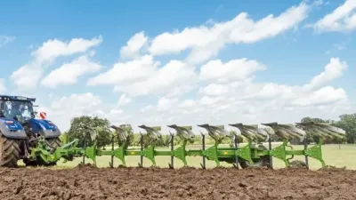 Traktor s dlouhým zeleným pluhem Amazone Hektor při orbě