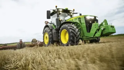 Zelený traktor John Deere při práci na poli