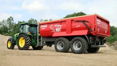 Červený sklápěč Krampe za traktorem John Deere