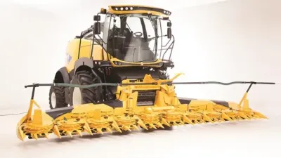 Žlutá sklízecí řezačka New Holland s žacím adaptérem