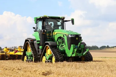Zelený pásový traktor John Deere na poli