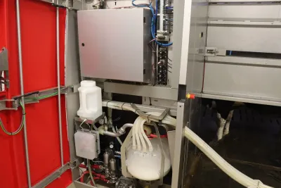 Na fotografii můžeme vidět útroby robota a proud mléka, u kterého je pokaždé kontrolována kvalita