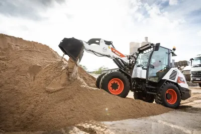 Kompaktní nakladač Bobcat u hromady sypkého materiálu