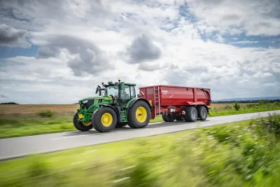 Zelený traktor John Deere 6R 185 na poli