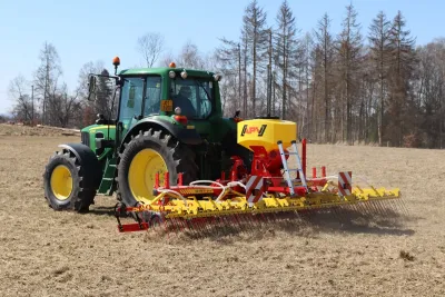 Traktor John Deere s lučními branami APV na louce
