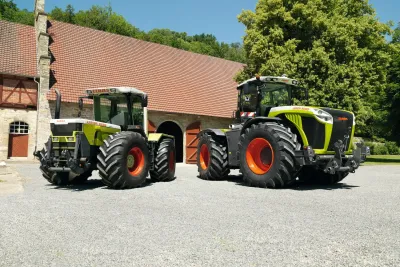 Dva traktory CLAAS XERION před historickou budovou.