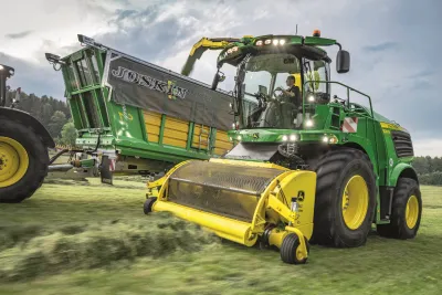 Zelená sklízecí řezačka John Deere při sklizni píce.