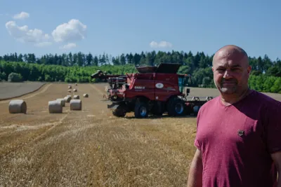 Zemědělec stojí na sklizeném poli před kombajnem Case IH.