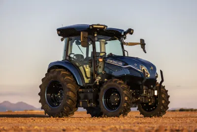 Modrý elektrický traktor New Holland na poli.