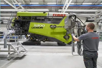 Pracovník u sklízecí mlátičky CLAAS LEXION ve výrobním závodě.