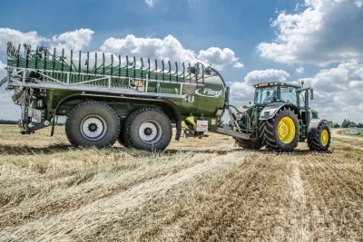 Traktor s cisternovým přívěsem Fliegl na poli.
