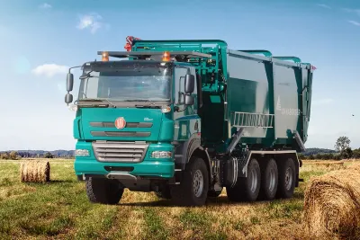 Zelený nákladní automobil Tatra na poli se senem