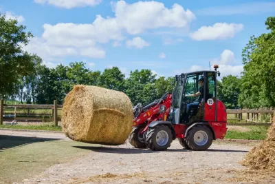 Červený elektrický nakladač Weidemann převáží kulatý balík