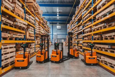 Oranžové skladové vozíky Doosan mezi regály s náhradními díly