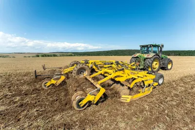 Traktor se žlutým diskovým podmítačem BEDNAR na poli